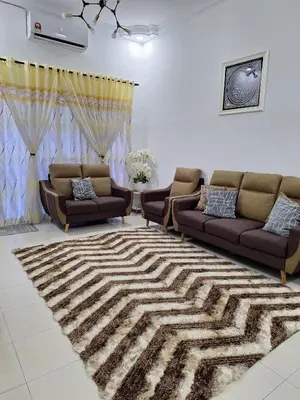 a living room with two couches and a rug at Rosselle Homestay, Sabak Bernam in Sabak Bernam