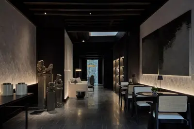a restaurant with black walls and tables and chairs at Soori Penang in George Town