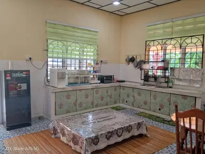 a kitchen with a table in the middle of a room at Shaja Homestay in Kampong Kepayang