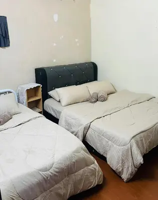 a room with two beds and a couch at laman terrace in Sungai Petani