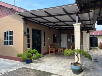 a patio with awning on the side of a house at Homestay ABAH in Nibung Tebal