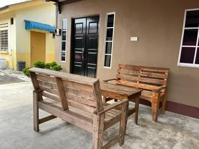 two wooden benches sitting in front of a building at Homestay ABAH in Nibung Tebal