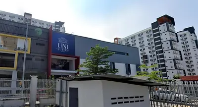 a building in front of some tall buildings at Unisuites Kampar Studio UTAR TARC -3pax, Pet Friendly, FREE 1 Carpark & Netflix in Kampar