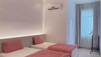 a room with two beds and a air conditioner at Alle House by Wei in Kampong Gurun