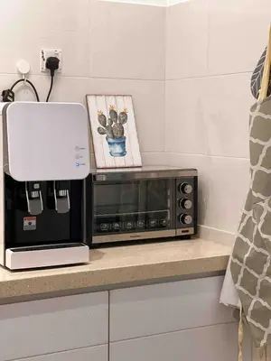 a microwave sitting on a counter with a picture at Alle House by Wei in Kampong Gurun