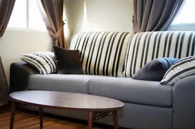 a couch with pillows and a coffee table in a living room at Good Luck Inn in Ayer Itam