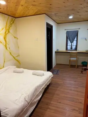 a bedroom with a bed in a room with a table at MR B hotel in Bukit Mertajam