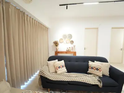a living room with a blue couch and curtains at Cozy Seaview Escape 2BR 6pax bythesea bathroom in Pulau Pinang