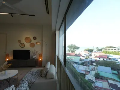 a living room with a view of a city at Cozy Seaview Escape 2BR 6pax bythesea bathroom in Pulau Pinang