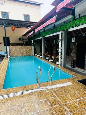 a swimming pool with two metal faucets next to a building at The Century Hostel George Town \u4e54\u6cbb\u5e02\u4e16\u7eaa\u9752\u65c5 in George Town