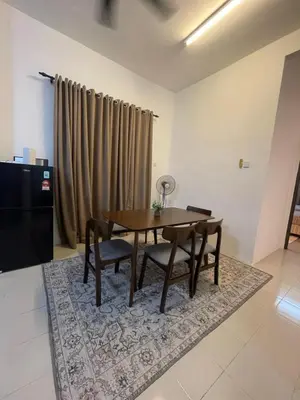 a dining room with a table and chairs on a rug at Orked Homestay 2 Parit Buntar in Parit Buntar