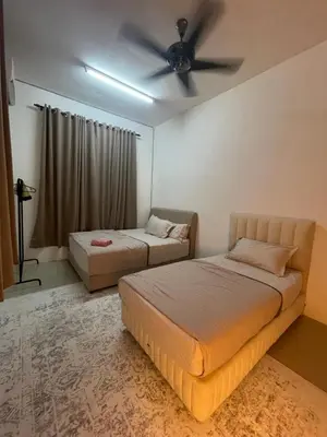 two beds in a room with a ceiling fan at Orked Homestay 2 Parit Buntar in Parit Buntar