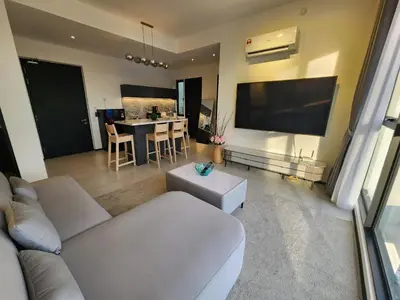 a living room with a couch and a flat screen tv at Urban Suite the Privilege Suites by Merveille in George Town
