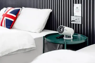 a bedroom with two beds and a table with a fan at i Homes Villa 3 Nearby Sunway - Swimming Pool and Karaoke in Ipoh
