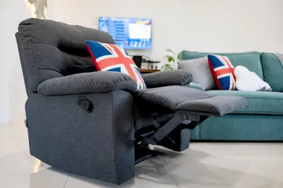 a grey reclining chair with cushions and a couch at i Homes Villa 3 Nearby Sunway - Swimming Pool and Karaoke in Ipoh