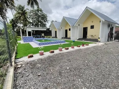 a house with a swimming pool in the yard at Desa Damai Homestay in Penaga