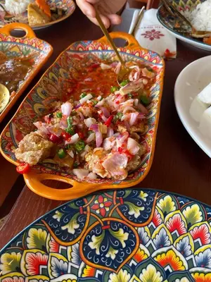 a bowl of food on a table with a person eating it at Easy Access to Airport, USM & Queensbay in Bayan Lepas
