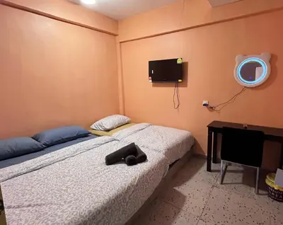 a bedroom with a bed and a tv on the wall at TY Youth Hostel in Sekincan