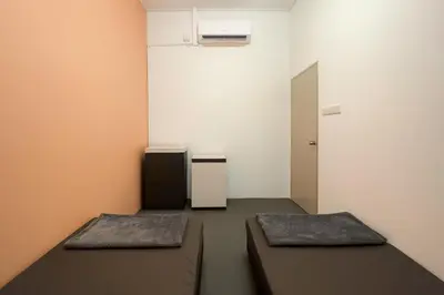 a room with two beds and a mirror at TK Homie in Tanjung Karang