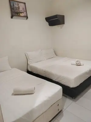two beds sitting next to each other in a room at JJ Hotel Sitiawan Perak in Sitiawan