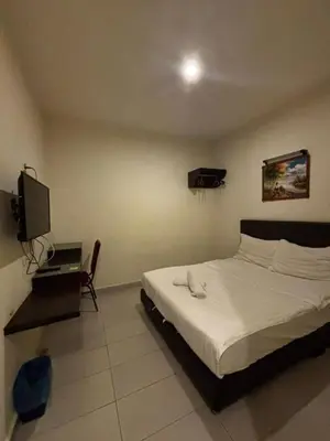 a bedroom with a bed and a television in it at JJ Hotel Sitiawan Perak in Sitiawan