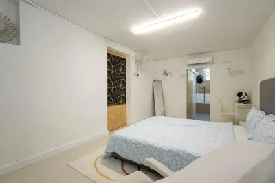 a white bedroom with a bed and a chair at Casa Celia - Pet allowed private parking studio in Ipoh