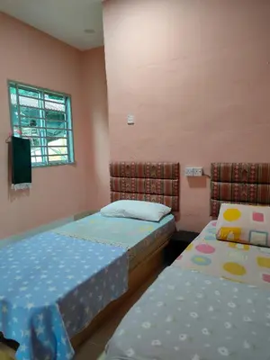 a room with two beds and a tv in it at Homestay Teratak Atas Bukit
