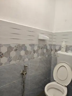 a bathroom with a toilet and a tiled wall at Homestay Teratak Atas Bukit