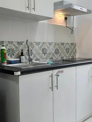 a kitchen with white cabinets and a sink at d01 The Anderson Ipoh Family Stay 2BR in Ipoh