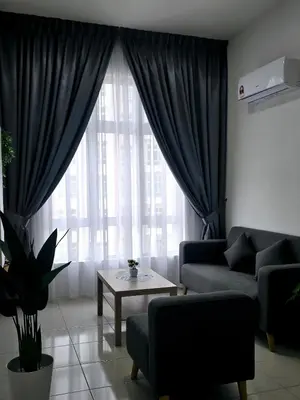 a living room with a couch and a table in front of a window at b06 The Anderson Ipoh Family Stay 2BR in Ipoh