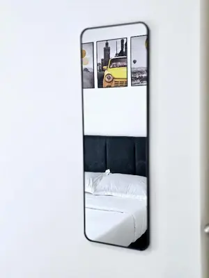 a mirror reflecting a bed and a yellow car at a04 The Anderson Ipoh Family Stay 2BR in Ipoh