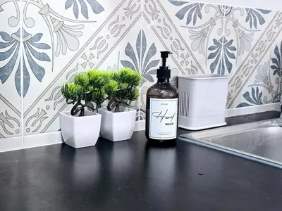 a bottle of wine sitting on a counter next to potted plants at b05 The Anderson Ipoh Family Stay 2BR in Ipoh
