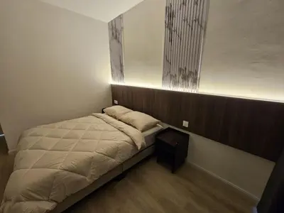 a small bedroom with a bed with a night stand at Roomstay KOBANAS in Ipoh