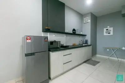 a kitchen with gray cabinets and a refrigerator at Jomstay Octagon Ipoh Penthouse in Ipoh