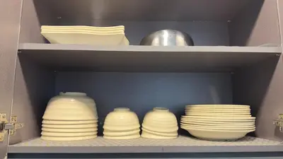 a group of plates and bowls on a shelf at Ether 665 Homestay in Sekincan