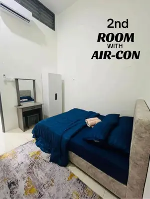 a bedroom with a blue bed and a couch at Puteri Resident In Stay in Sungai Petani
