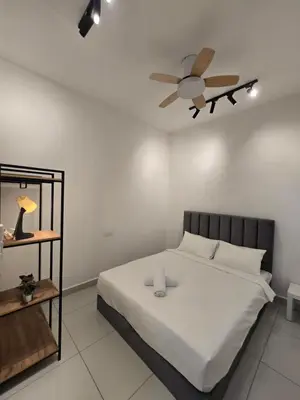 a bedroom with a bed with a ceiling fan at ICC Ipoh Bond Suites by Merveille Louise in Ipoh