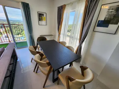 a dining room with a table and chairs and windows at Cameron Highland 910 The Garden 3BR 6 Pax in Brinchang