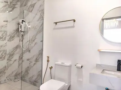 a bathroom with a toilet and a shower at Executive White Houze in Kepala Batas