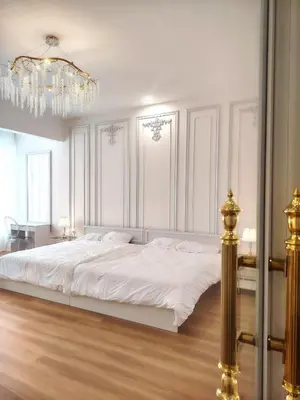 a white bedroom with a large bed and a chandelier at Executive White Houze in Kepala Batas