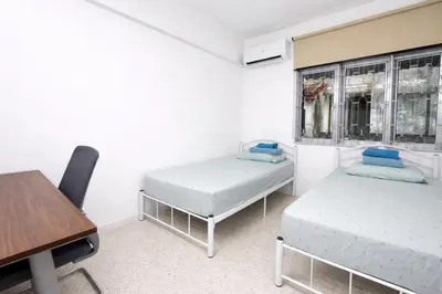 two beds in a room with a table and a desk at 3 Bedrooms Single Storey Terrace at Taman Inderawasih ,12mins to Penang Bridge , 5mins to Sunway Carnival Mall in Butterworth