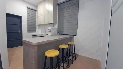 a kitchen with two stools and a counter in a kitchen at Tiara Homestay Bandar Baru Kuala Lipis in Kuala Lipis