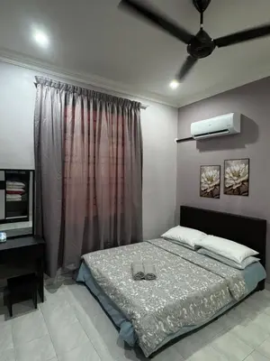 a bedroom with a bed with two shoes on it at Teratak Perdana in Sungai Petani