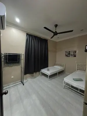 a room with two beds and a ceiling fan at Teratak Perdana in Sungai Petani