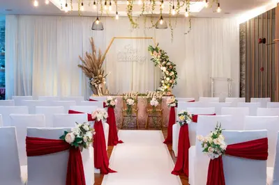 a wedding aisle with white chairs and red and white flowers at Olive Tree Hotel Penang in Bayan Lepas