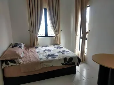 a bedroom with a bed with a window and a table at Iskandar SmartStay in Kampong Bota Road