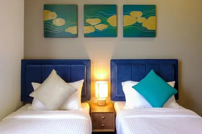 two beds sitting next to each other in a room at Penang Beachfront Seaview Residences in Tanjong Tokong