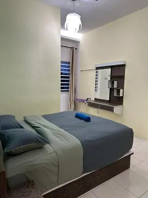 a bedroom with a large bed with a blue pillow on it at StichStay Cameron in Tanah Rata