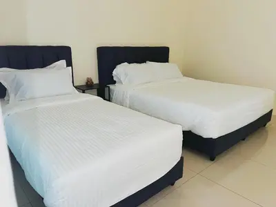 two beds sitting next to each other in a room at Cozy Private Room for Relaxing Stays in Nibung Tebal