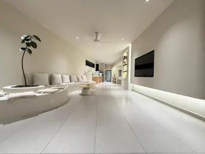 a living room with white furniture and a tv at Taiping Corner Homestay in Taiping